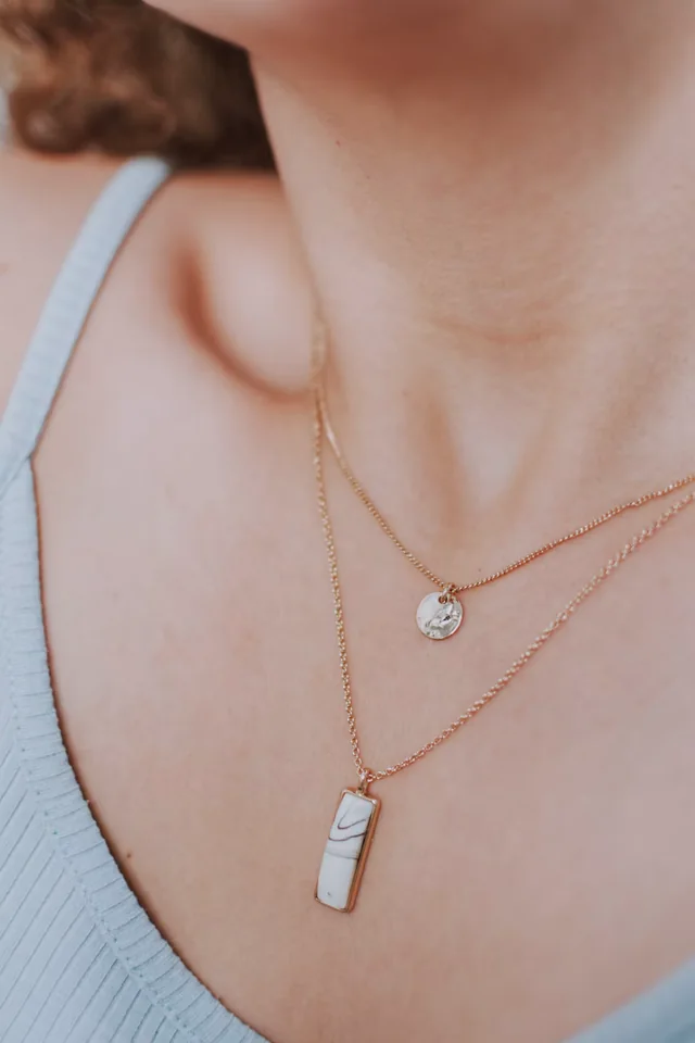Collana in oro con pendente su tessuto bianco